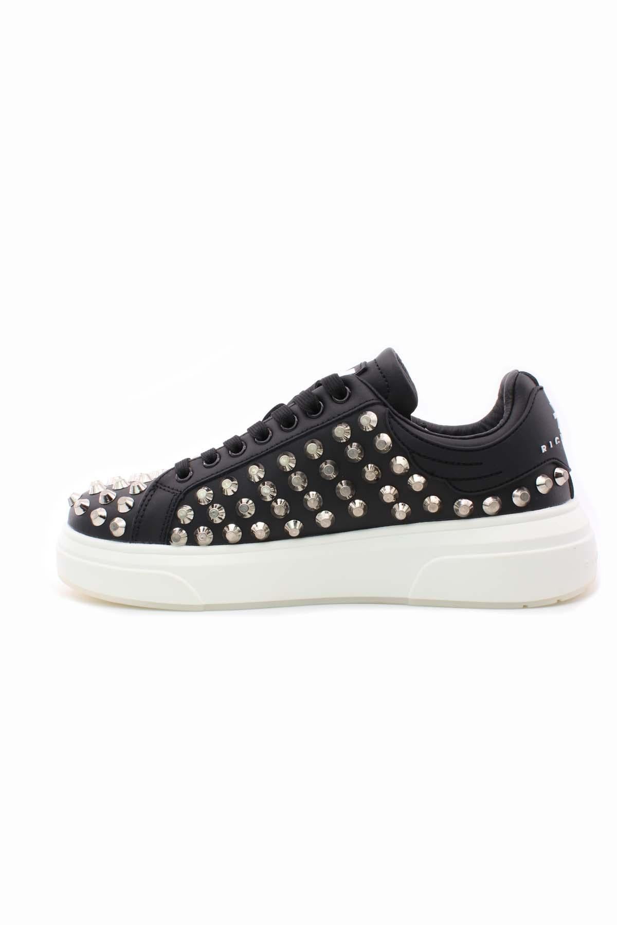 Sneakers con borchie e suola firmata