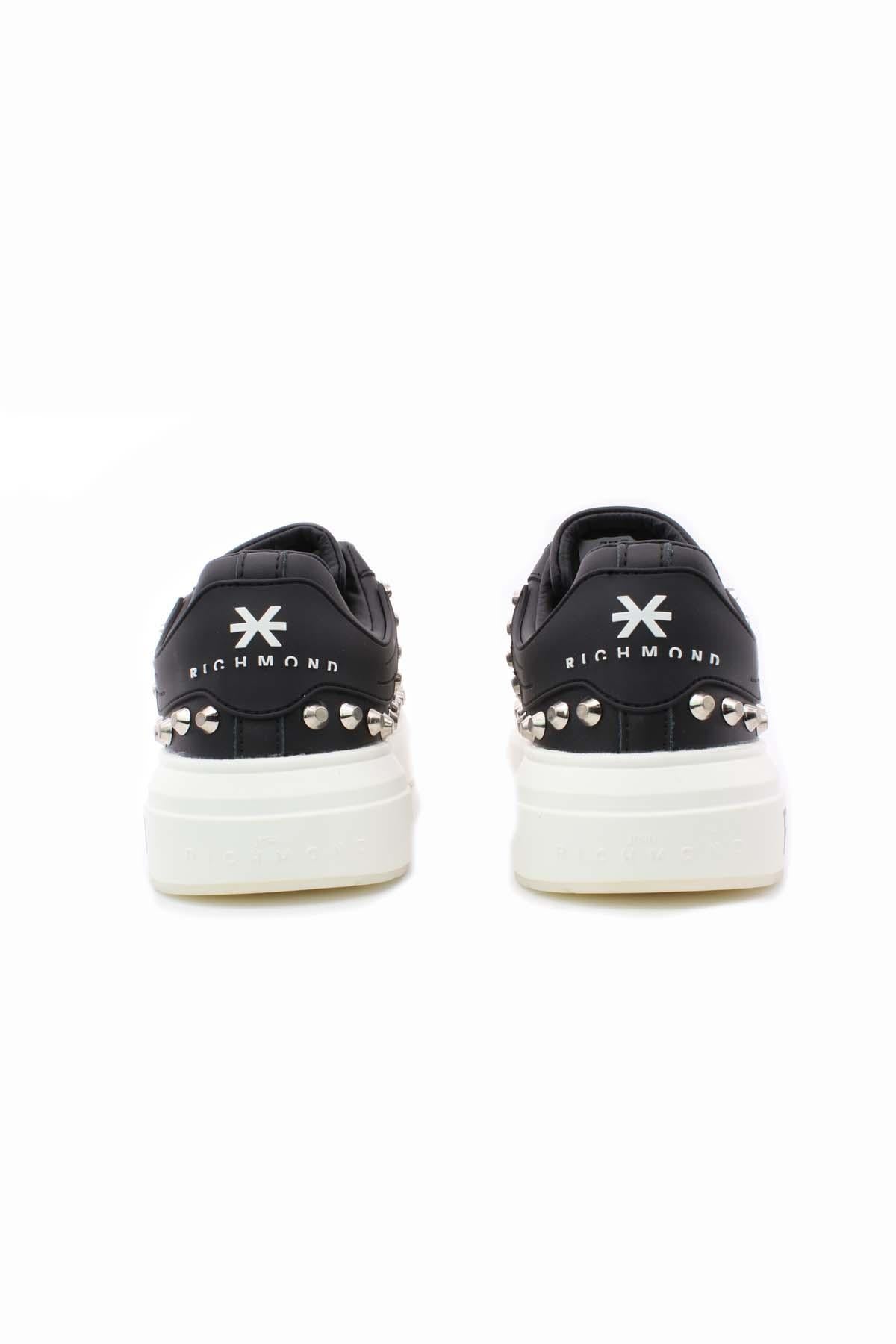 Sneakers con borchie e suola firmata
